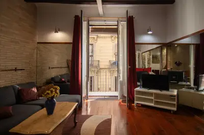 a living room with a couch and a tv at Gaudí Ramblas in Barcelona