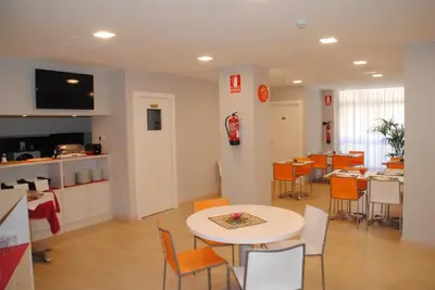 a room with a table and chairs and a kitchen at Hostal Aslyp 114 in Barcelona