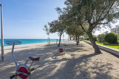 a bike parked on a beach next to the ocean at HomeHolidaysRentals Benoit - Costa Barcelona in Pineda de Mar
