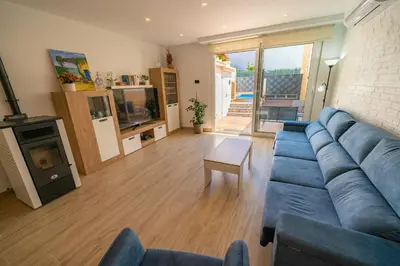 a living room with a blue couch and a fireplace at HomeHolidaysRentals Benoit - Costa Barcelona in Pineda de Mar