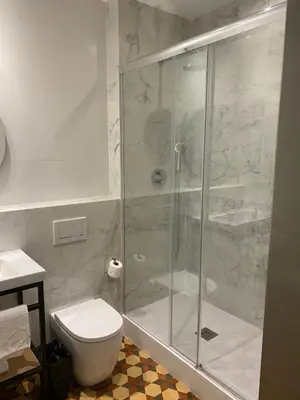 a bathroom with a glass shower with a toilet at Fontanella By BCN URBAN Rooms in Barcelona