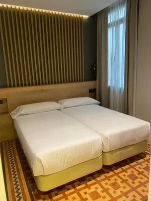a bedroom with two beds and a window at Fontanella By BCN URBAN Rooms in Barcelona