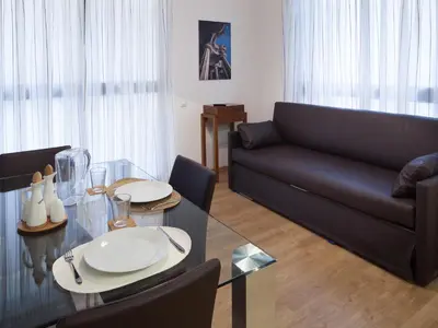 a living room with a black couch and a glass table at Casa Codina in Barcelona