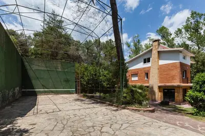 a building with a gate in front of a house at L'aviador de Can Ton in Sant Llorenc Savall