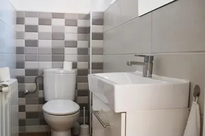 a bathroom with a white toilet and a sink at MonResidence Bellavista in Manresa