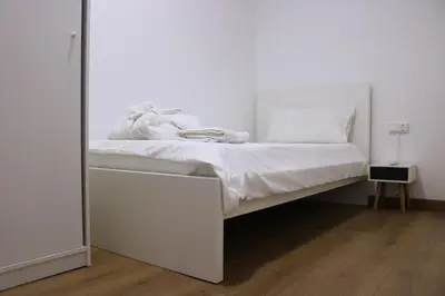 a white bed in a room with a mirror at MonResidence Bellavista in Manresa