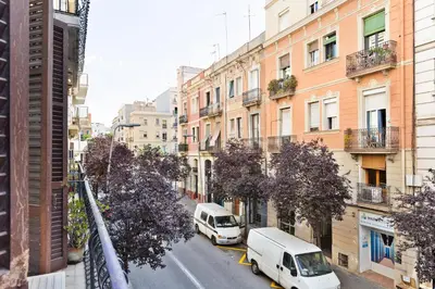 two white vans parked on a city street with buildings at Moianes Apartment by Olala Homes in Barcelona