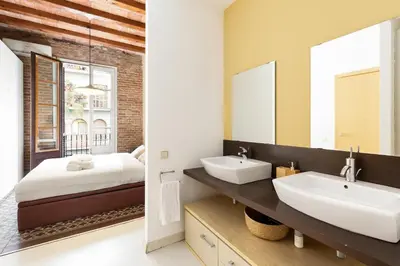 a bathroom with two sinks and a bed and a mirror at Moianes Apartment by Olala Homes in Barcelona