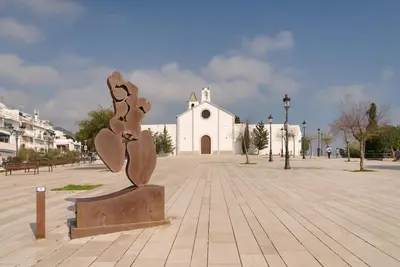 a statue in front of a church with a building at Sitges in centrum close to the beach in Sitges