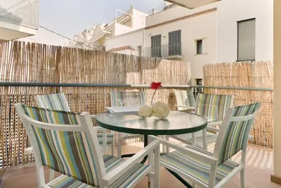 a glass table and chairs on a balcony at Sitges in centrum close to the beach in Sitges