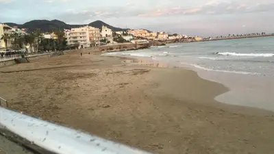 a view of a beach with buildings and the ocean at Sitges in centrum close to the beach in Sitges