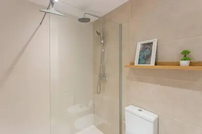 a bathroom with a shower and a toilet with a glass door at New Apartment With Private Rooftop in Hospitalet de Llobregat