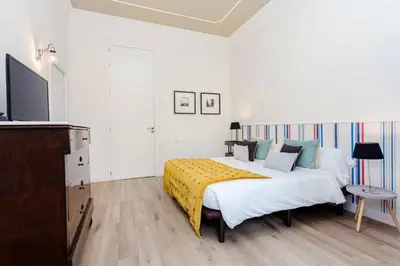 a bedroom with a bed with a yellow blanket on it at Luxury 4bdr In Gracia in Barcelona