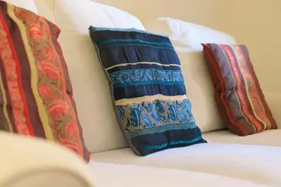 a couch with three pillows on top of it at Housalia Gracia in Barcelona