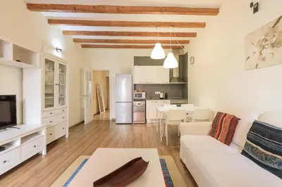 a living room with a white couch and a table at Housalia Gracia in Barcelona