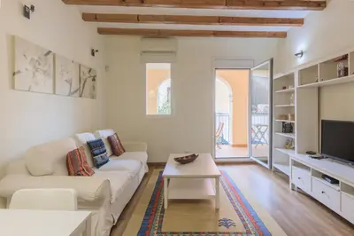 a living room with a white couch and a tv at Housalia Gracia in Barcelona