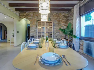 a dining room with a table with plates and silverware at Villa Nirvana by Hello Homes Sitges in Sitges