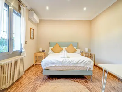 a bedroom with a bed and a large window at Villa Nirvana by Hello Homes Sitges in Sitges