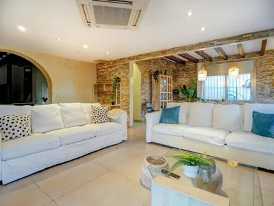 a living room with white couches and a brick wall at Villa Nirvana by Hello Homes Sitges in Sitges