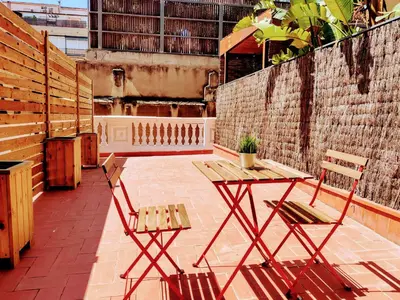 a patio with two chairs and a wooden table and bench at Hostal Live Natura Barcelona in Barcelona