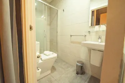 a white bathroom with a toilet and a sink at Hostal Live Natura Barcelona in Barcelona