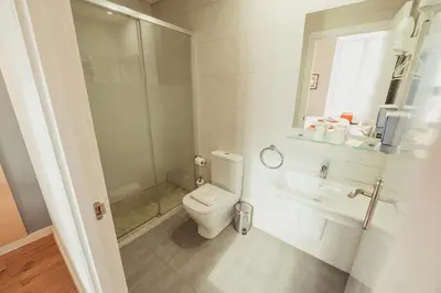 a white bathroom with a toilet and a sink at Hostal Live Natura Barcelona in Barcelona