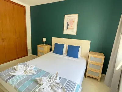 a bedroom with a bed with blue and white pillows at Sant Pau Beach Home with terrace in Sitges