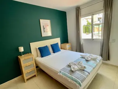a bedroom with a bed with blue walls and a window at Sant Pau Beach Home with terrace in Sitges