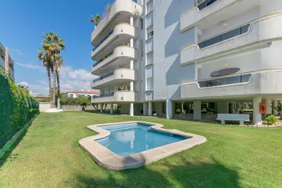 a large apartment building with a swimming pool in the yard at ESTRELLA DE MAR Sitges in Sitges