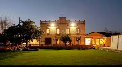 a large house with lights on the front of it at Masia La Bomba in Masnou