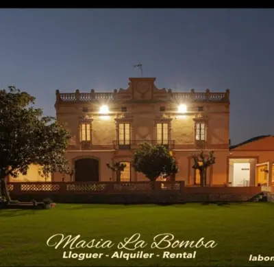 a large building with lights on the front of it at Masia La Bomba in Masnou