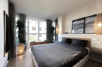 a bedroom with a large bed and a large window at SONORA - Bright Apartment with view of Sagrada Familia in Barcelona