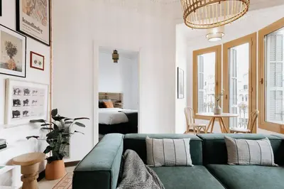 a living room with a green couch and a bedroom at LLANOS - Two Bedroom apartment in heart of the city in Barcelona
