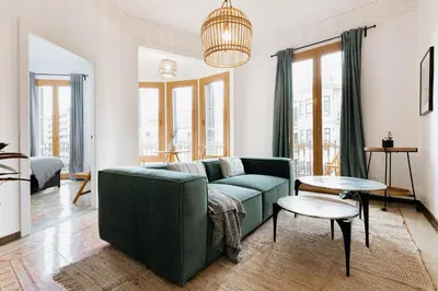 a white wall with framed pictures and a plant at LLANOS - Two Bedroom apartment in heart of the city in Barcelona