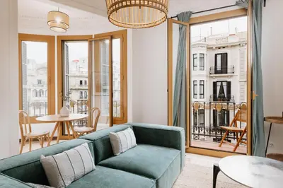 a living room with a green couch and a table at LLANOS - Two Bedroom apartment in heart of the city in Barcelona