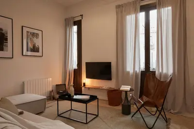 a kitchen with black and white cabinets and a stool at DENALI - Stylish apartment in center of Barcelona in Barcelona