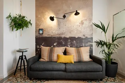 a couch in a living room with two plants at ROVIRA - One bedroom apartment in Penedes in Barcelona