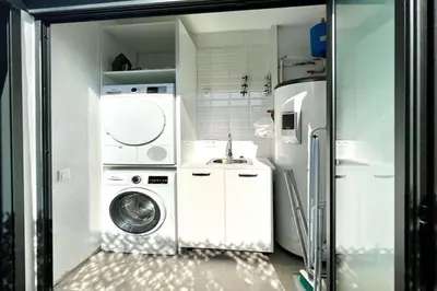 a kitchen with a washing machine and a refrigerator at Hauzify I Apartaments Sant Pau in San Pol de Mar