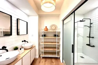 a bathroom with two sinks and a shower at Hauzify I Apartaments Sant Pau in San Pol de Mar