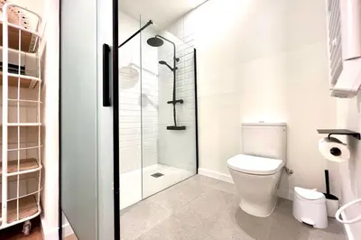 a bathroom with a toilet and a glass shower at Hauzify I Apartaments Sant Pau in San Pol de Mar