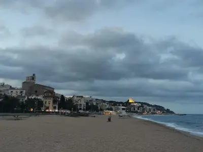a sandy beach with buildings and the ocean at Hauzify I Apartaments Sant Pau in San Pol de Mar