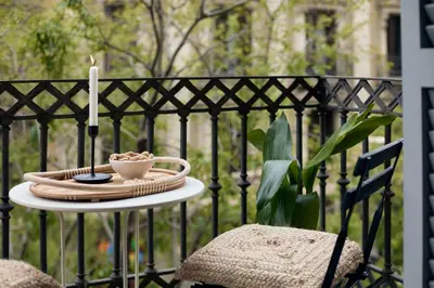 a table with a candle and a cup on a fence at ERAWAN - One bedroom apartment in Eixample in Barcelona