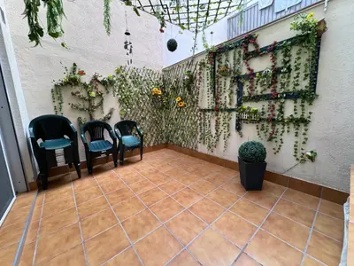 a patio with chairs and plants on a wall at BADAROSA House Badalona next to Barcelona & beach in Badalona