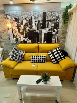 a yellow couch in a living room with a city mural at BADAROSA House Badalona next to Barcelona & beach in Badalona