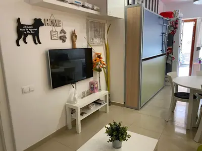 a living room with a flat screen tv on a wall at BADAROSA House Badalona next to Barcelona & beach in Badalona