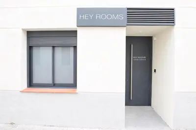 a white building with a key rooms sign and a door at Hey Rooms in Cerdanyola del Valles