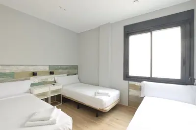 a white room with two beds and a window at Hey Rooms in Cerdanyola del Valles