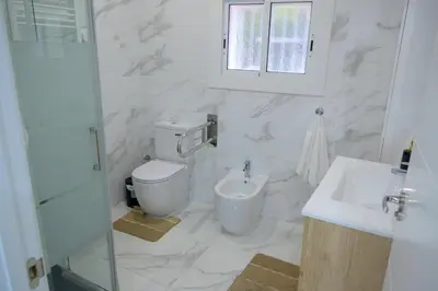 a white bathroom with a toilet and a sink at Relax House Barcelone in Sant Esteve Sesrovires