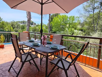 a table and chairs with an umbrella on a balcony at Relax House Barcelone in Sant Esteve Sesrovires