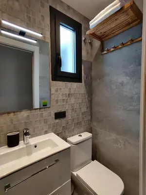 a bathroom with a toilet and a sink and a mirror at Stylish apartments Camp Nou in Hospitalet de Llobregat